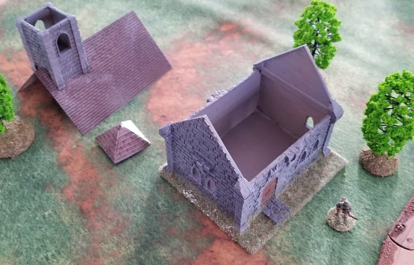 Miniature model of a church with trees and a figure on a textured surface