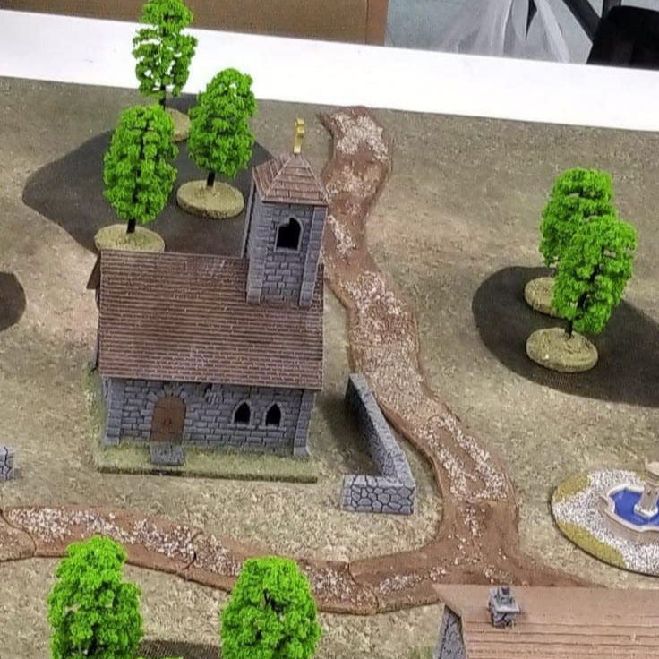 Model village with houses, trees, and a path on a table
